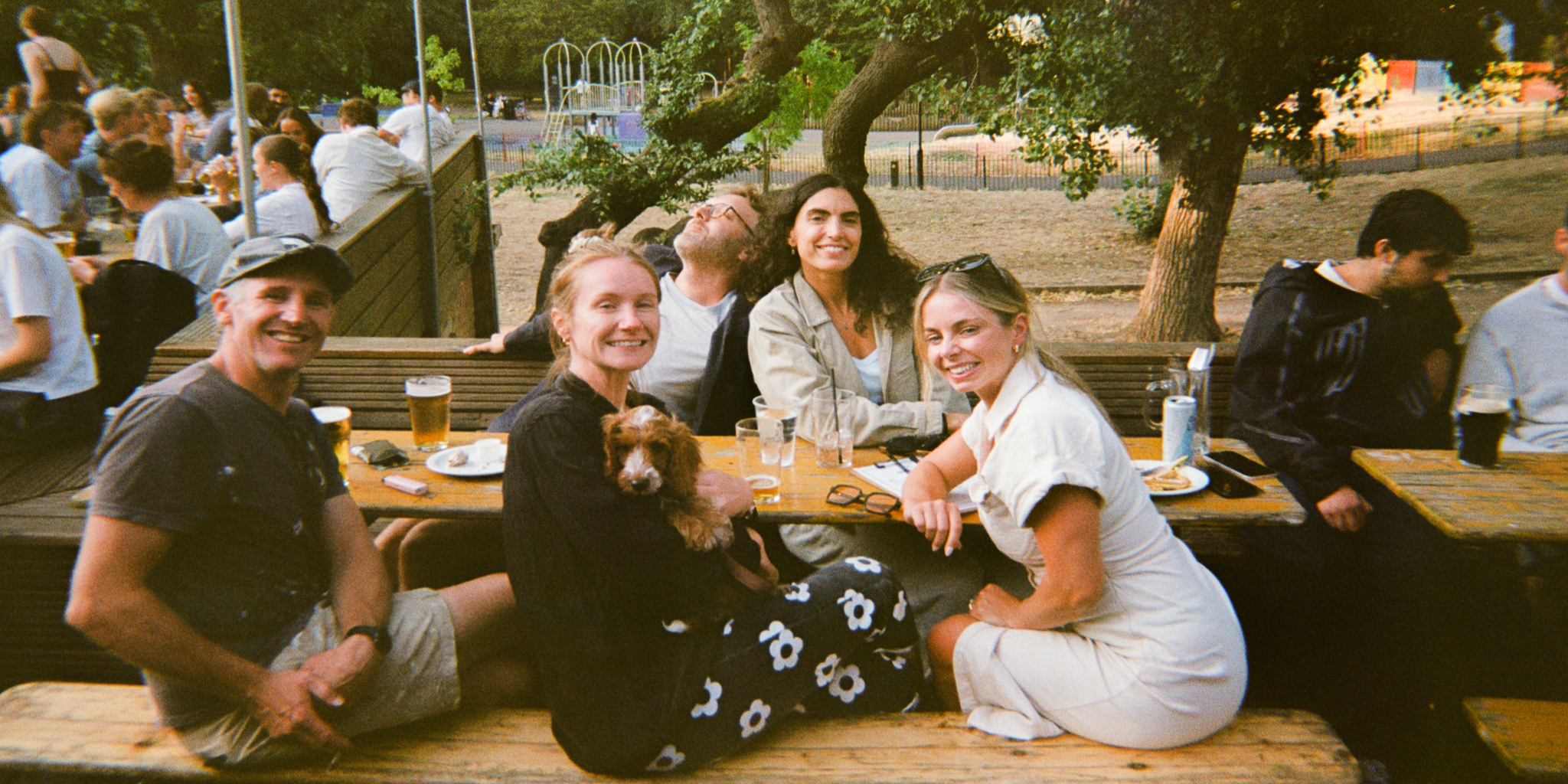 Photo of a group of friends and their dog all smiling for the camera