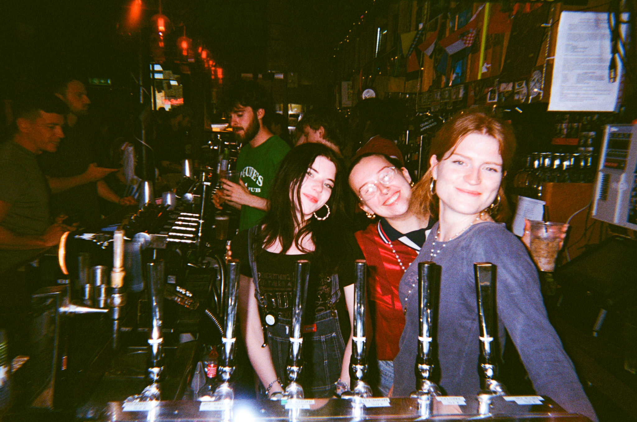 Photo of three team members behind the bar at pub on the park smiling for the camera