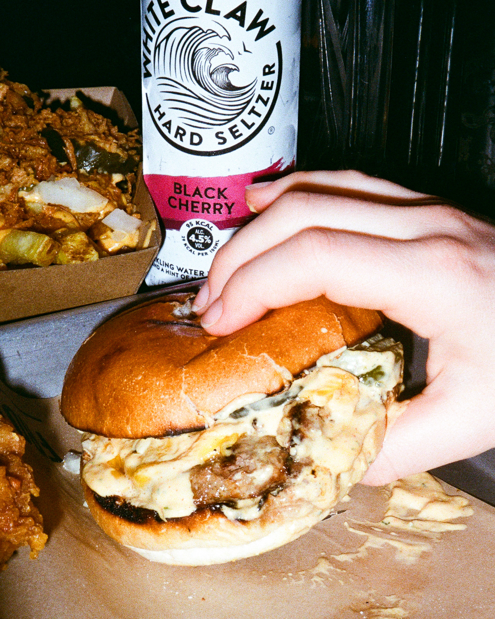 Photo of a hand picking up a burger