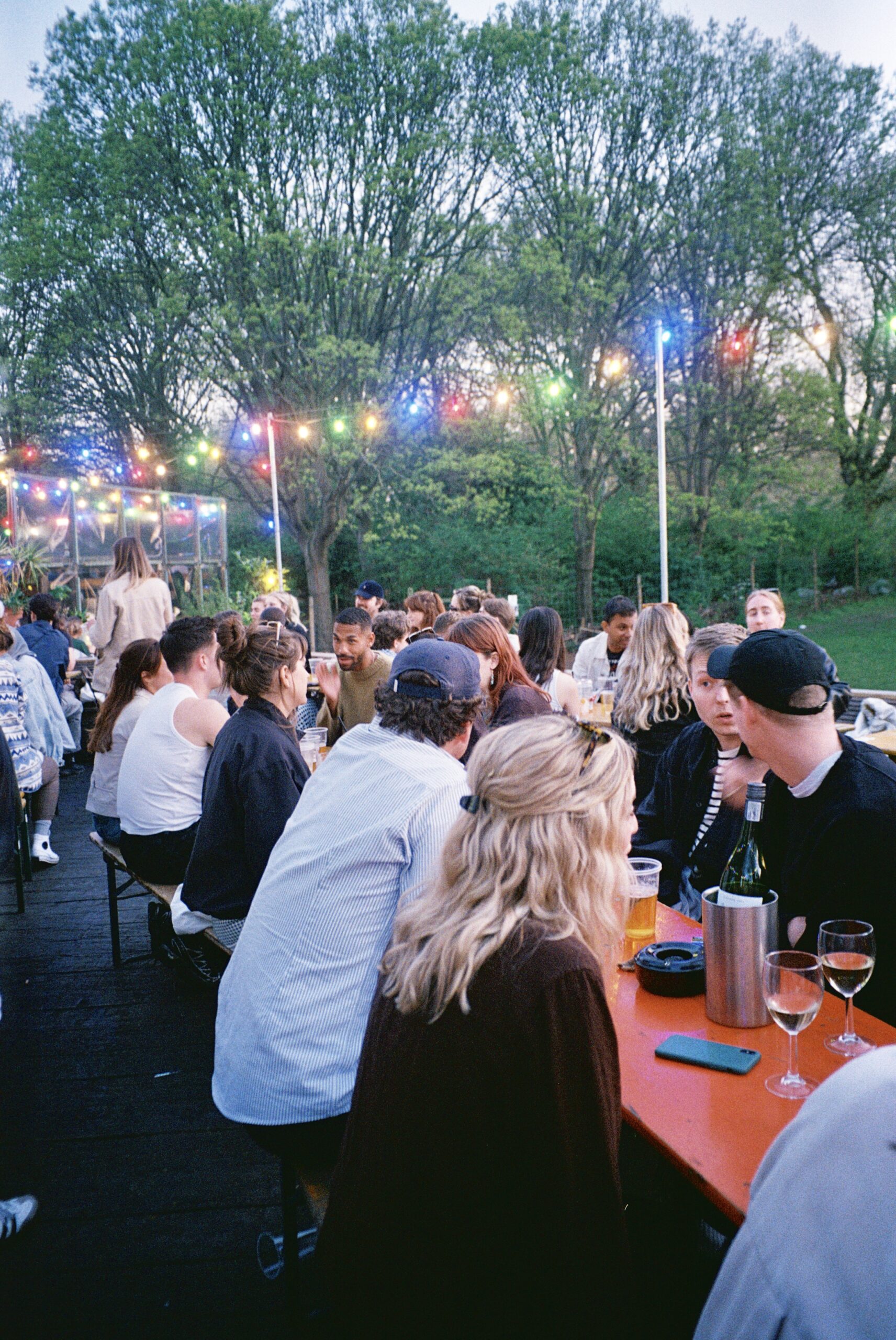 Photo of people seated outside on deck three at pub on the park